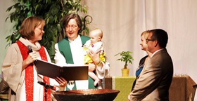 Bishop Elaine J.W. Stanovsky baptizes the daughter of two elders during the 2013 Rocky Mountain Annual Conference. File photo, United Methodist Communications.
