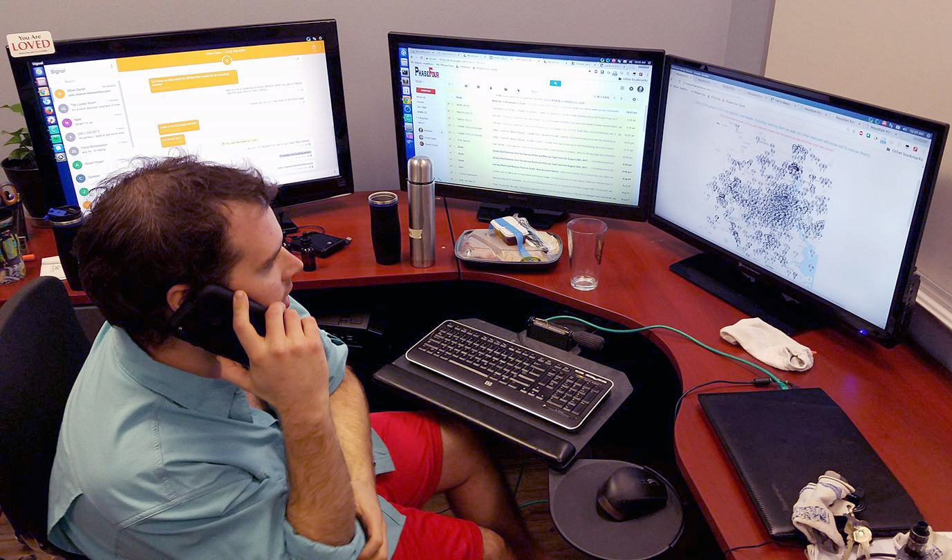 Matthew Marchetti, a member of Chapelwood United Methodist Church in Houston, looks at three computer screens as he works to locate people who need rescuing during Hurricane Harvey. Marchetti, along with fellow Chapelwood member Oliver Carter, came up with a design for a web app, HoustonHarveyRescue.com, to help connect those in need with volunteer rescuers. Photo courtesy of Matthew Marchetti.