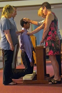 A young man is confirmed by his pastor. 