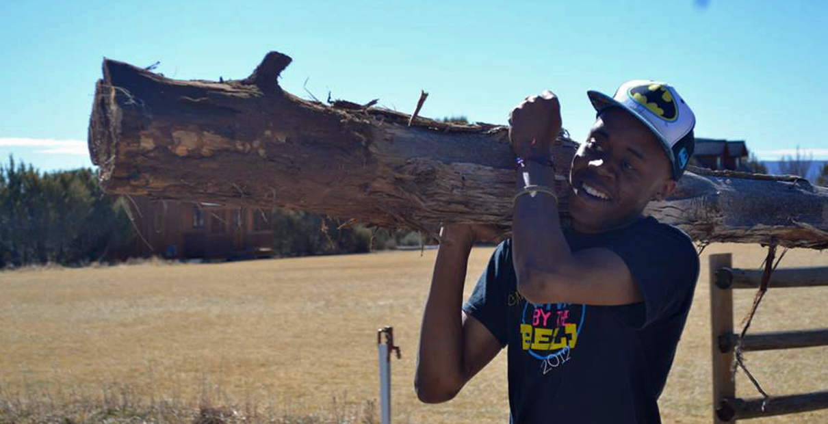 Dakarayi Chabaya, student at Central Methodist University carries a log during one of his mission trips. Photo courtesy of Dakarayi Chabaya.