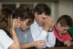 Young adults whose parents shared the importance of their faith are far more likely to continue in church. Members of the Bonn family pray during a 2014 service at Christ United Methodist Church in Franklin, Tenn., to lift up those facing the Ebola crisis in West Africa. Photo by Mike DuBose, United Methodist Communications.