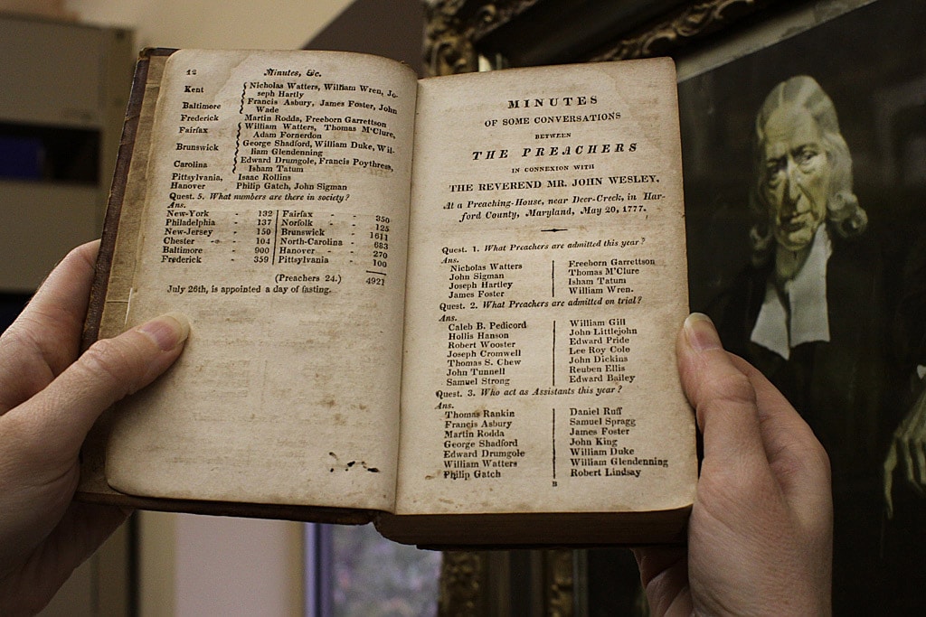 An archivist holds a book listing early Methodists. Photo by Kathleen Barry, United Methodist Communications. 