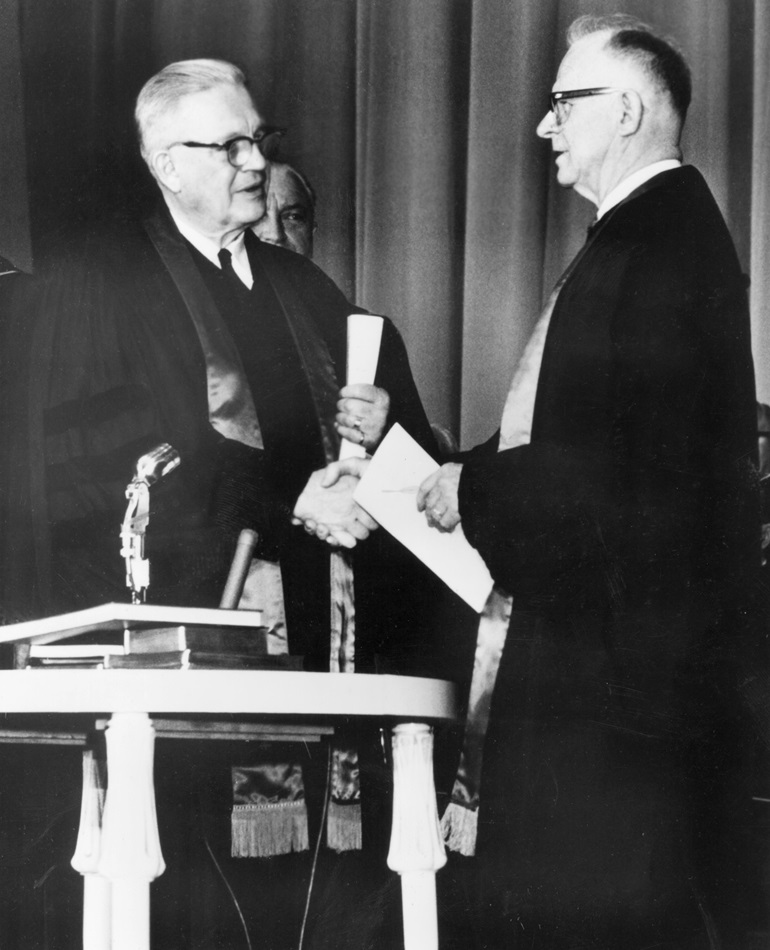 Evangelical United Brethren Church Bishop Reuben H. Mueller (left) and Methodist Bishop Lloyd C. Wicke join hands on April 23, 1968.