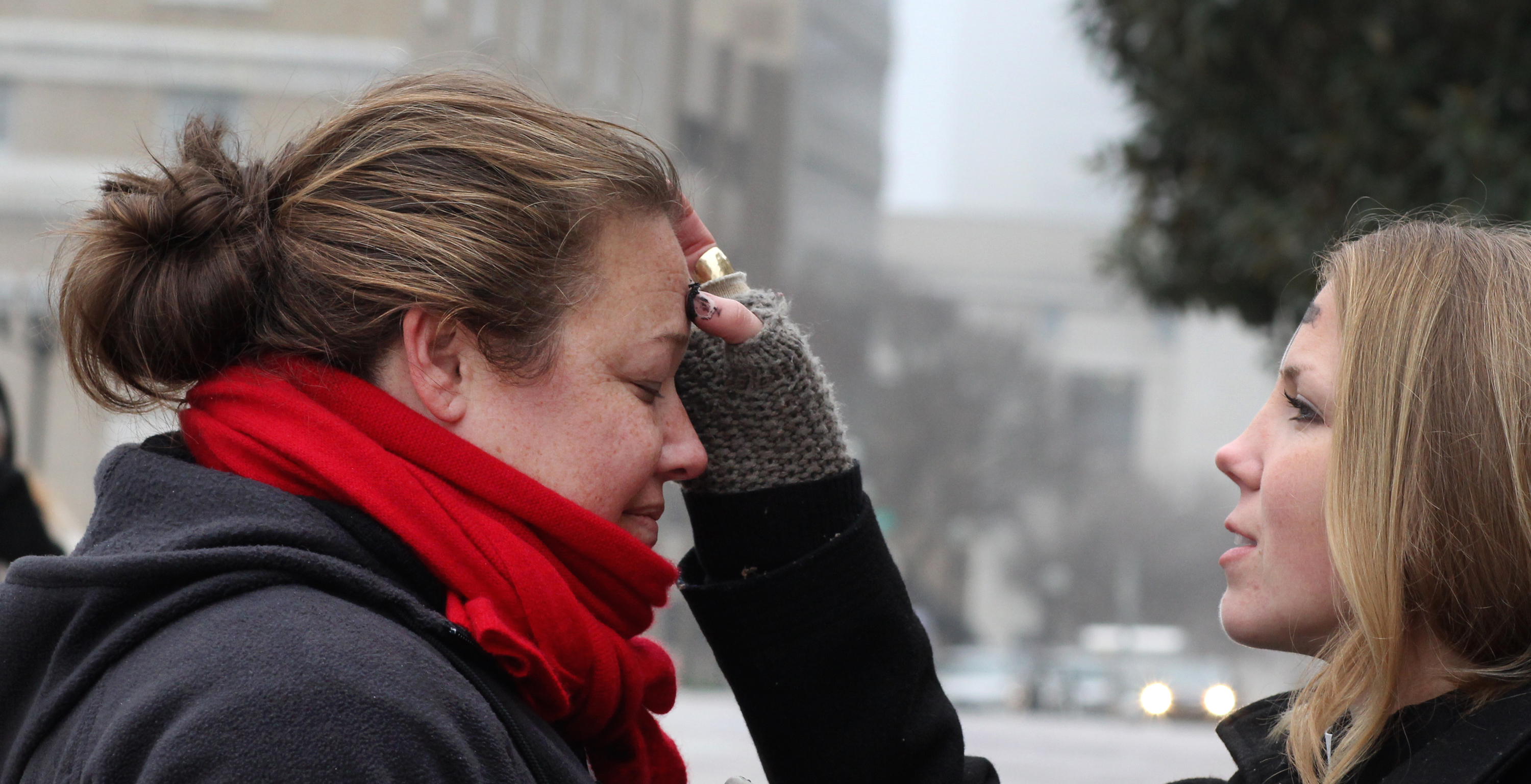 Ingrid McIntyre receives ashes from street chaplain, Lindsey Krinks. About 30 people gathered as a community to share in the Ash Wednesday liturgy and to raise awareness of those suffering from homelessness and poverty. McIntyre is a member of Christ United Methodist Church in Franklin, Tenn. A file photo from 2014 by Kathleen Barry, United Methodist Communications.