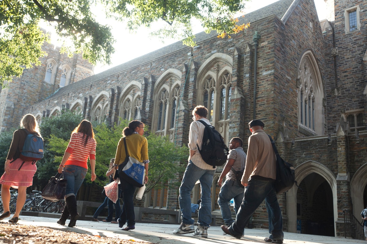 Students walk on the academic quad with Perkins Library in background on the campus of Duke University. Photo by Les Todd, Duke University
