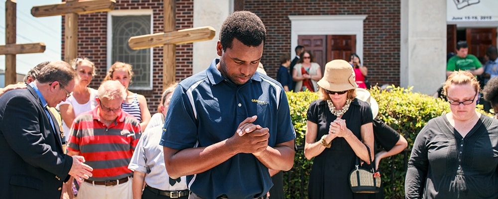 Robert Griggs (center) prays with others outside Morris Brown African Methodist Episcopal Church in Charleston, S.C. United Methodists joined AME members in prayers following the deadly shooting at Emanuel AME Church in Charleston. 
