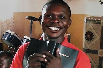 This smile shows the happiness felt by a man in the Democratic Republic of the Congo who is holding a Bible in his own language. Photo courtesy Asbury United Methodist Church.
