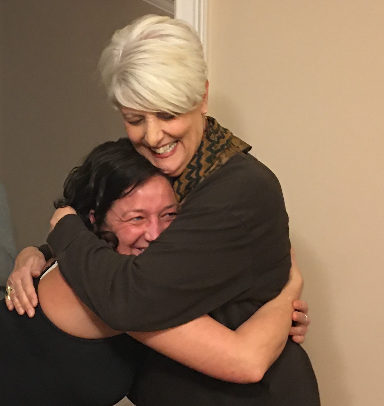 Volunteer Pat Ralls (top) hugs a Healing Housing resident. 