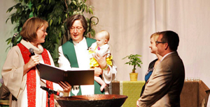 Baptism unites us as a community of faith, as Bishop Elaine J.W. Stanovsky illustrated in the baptism of the daughter of two elders during the 2013 Rocky Mountain Annual Conference. File photo, United Methodist Communications.