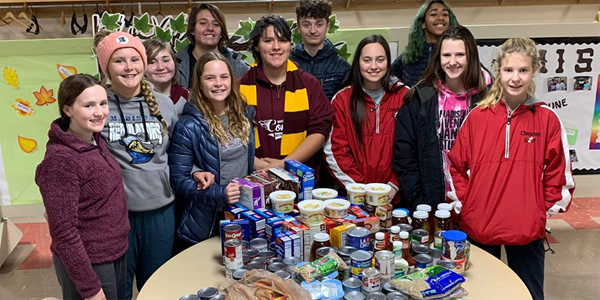 Youth in Madison gather around some of the food items collected. Courtesy Photo. Youth in Madison gather around some of the food items collected. Courtesy Photo.