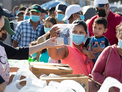 Migrants living in a makeshift camp near the El Chaparral border crossing in Tijuana, Mexico, receive food and other relief supplies from Nuevo Pacto Methodist Church and San Pablo Evangelical Church in Tijuana. Some 1,500 migrants have taken up residence there, many of them hoping to present asylum claims to U.S. immigration authorities. Photo: Mike Dubose, UMNews