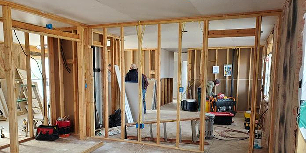 Volunteers work inside one of the houses being rebuilt after the devastating 2020 Okanagan fires. Courtesy Photo: GBGM.