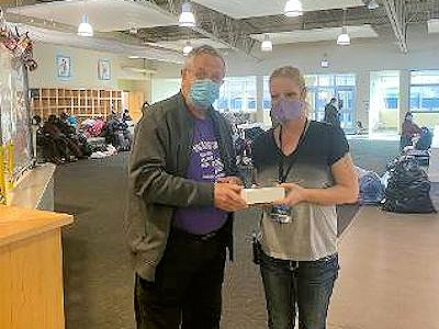 Even during the pandemic, HON (Helping Our Neighbors) is bringing help to the homeless. Kalamazoo First UMC member Dick Shilts gives a cell phone with a year of paid service to a HON client. ~photo courtesy Dick Shilts.