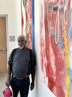 Larry Magee with the two giant paintings he completed for the Ferman Center For The Arts at the University of Tampa. Courtesy photo.
