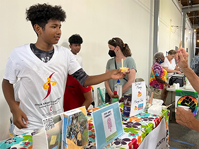 Pedro, a member of the Open Arms youth group, serves up some Mango con Chili sorbet at the 2022 Big Chill. Photo: Julie Wilson.