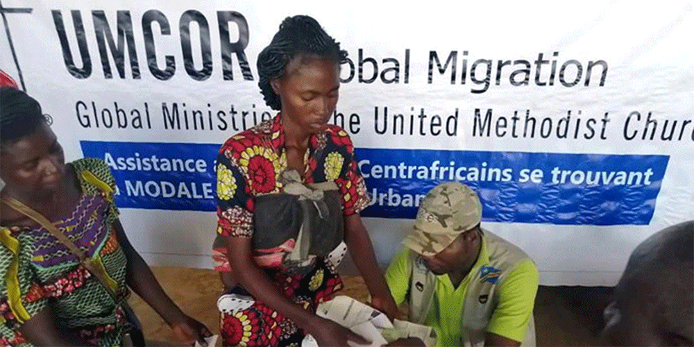 Two displaced Central African women receive an envelope containing money to buy food. The United Methodist Committee on Relief provided $50,000 to assist nearly 1,000 displaced families from the Central African Republic living in a refugee camp in Limasa, Congo. Photo courtesy of the Eastern Congo disaster management office.