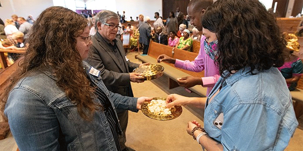 Acacia Zuninga (left) and the Rev. Jorge Ramirez offer Holy Communion during a Festival of Nations celebration of World Communion Sunday at Hillcrest United Methodist Church in Nashville, Tenn. They help lead the Casa de TransformaciÃ³n congregation that worships at Hillcrest.