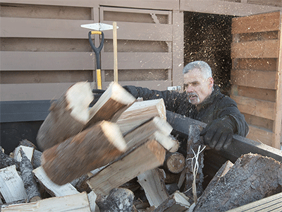 Jimmie Hutson loads firewood that he will use to help heat his home from a woodshed at the Willow (Alaska) Community Food Pantry. Hutson is both a regular volunteer at the pantry and occasionally receives aid from the program. Photo by Mike DuBose, UM News.