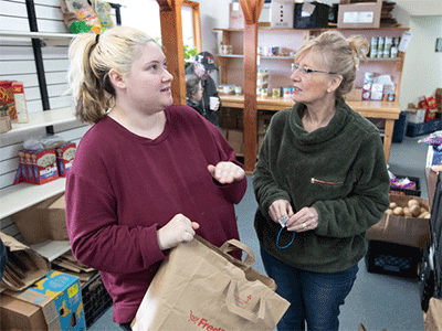 Lilyahna Bohlare (left) visits with volunteer Berna Brooks while selecting groceries at the Willow (Alaska) Community Food Pantry.