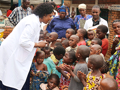 Dr. Marie Claire Manafundu, who coordinates the church’s Maternal and Child Health Program in eastern Congo, talks with children outside of United Methodist Irambo Health Center in Bukavu, Congo. The United Methodist Church in East Congo offers food support to families affected by HIV and AIDS. Photo by Philippe Kituka Lolonga, UM News.