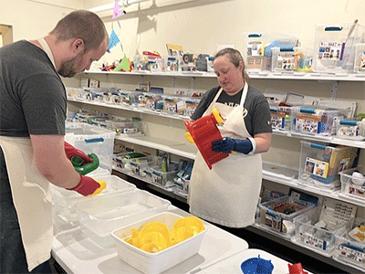 Tara and Anthonee sort, wash and sanitize toys and boxes at the Toy Lending Library.