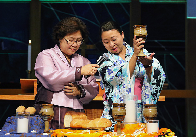 The Revs. Pauline Kang and Motoe Foor lead Holy Communion during opening worship at the 2018 Ohana Conference in Honolulu held by the Association of Asian American and Pacific Islander Clergywomen (AAPIC) and National Association of Korean American United Methodist Clergywomen (NAKAUMC). Photo by Thomas Kim, UM News.