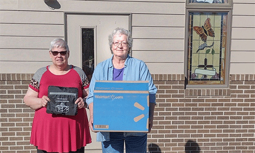 Sandy Krumvieda, left, holds up a duffle bag and Adele Kpp, right shows a box of duffle bags ready for delivery. Photo courtesy of Montrose UMC.