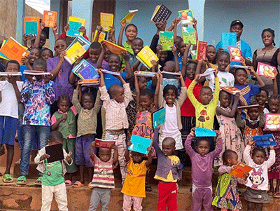 Children in Cameroon hold up their new Sunday school curriculum. UMC Global Mission Fellow, Carlito Alberto (back row, second from right), is a teacher and coordinator of child and youth work with the Cameroon church. Photo: Courtesy of Carlito Alberto