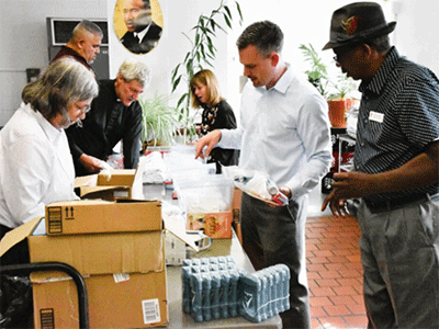 EPA Conference Lay Leader William Thompson Sr. (right), and the Rev. Allen Keller (second from left) also help fill bags with toiletries.