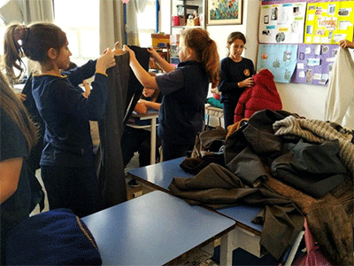 Students from Crandon Salto school in Uruguay sort and fold coats and clothes for their winter clothing drive. (Photo: Courtesy of Crandon Salto school)