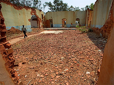 The Rev. Simao Antonio, pastor of Eva de Andrade United Methodist Church in Malanje, Angola, walks through the ruins of his former elementary school, the school of "Love and Happiness," at the Quéssua Methodist Center. Quéssua was bombed out of existence at the beginning of the country's long civil war, in an act of revenge against the first president of Angola, who was a United Methodist. 2006 file photo by Mike DuBose, UM News.