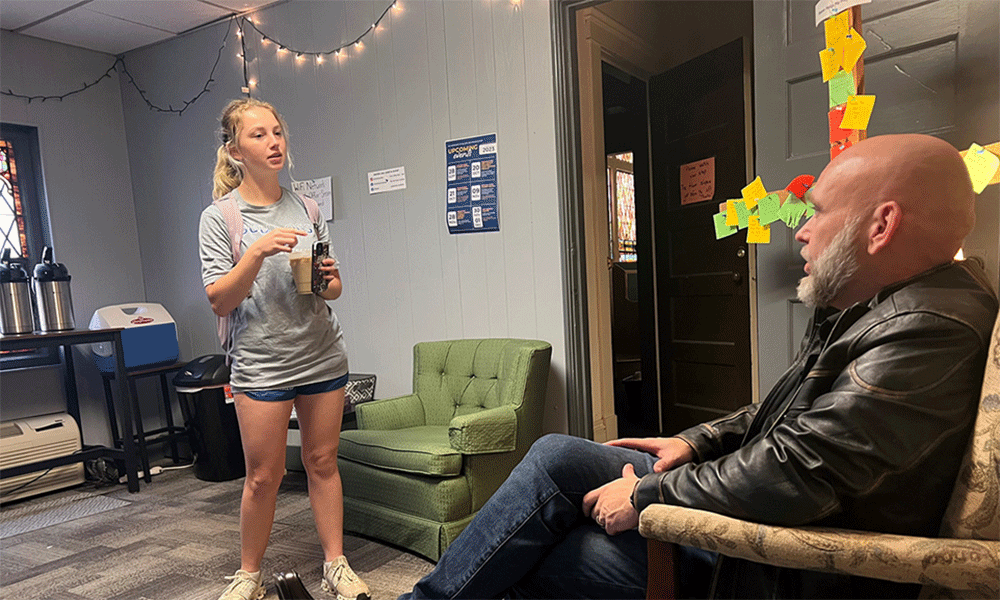 Tennessee Wesleyan student Jozlyn Long (left) stops by Trinity Coffee during finals week, pausing to chat with the Rev. Skip White.