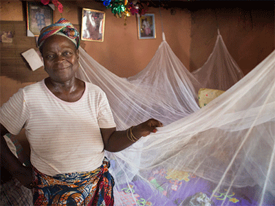 Matilda Ndanema displays the insecticide-treated mosquito net she received from the United Methodist Church’s Imagine No Malaria campaign at her home in Sierra Leone. (Photo: Mike DuBose, UM News)
