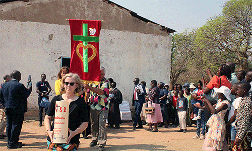 Members of Union United Methodist Church in Irmo, South Carolina, lead a procession from the old United Methodist Chitenderano Church sanctuary in Rusape, Zimbabwe, to a new sanctuary their church helped to build. Photo by Kudzai Chingwe, UM News.