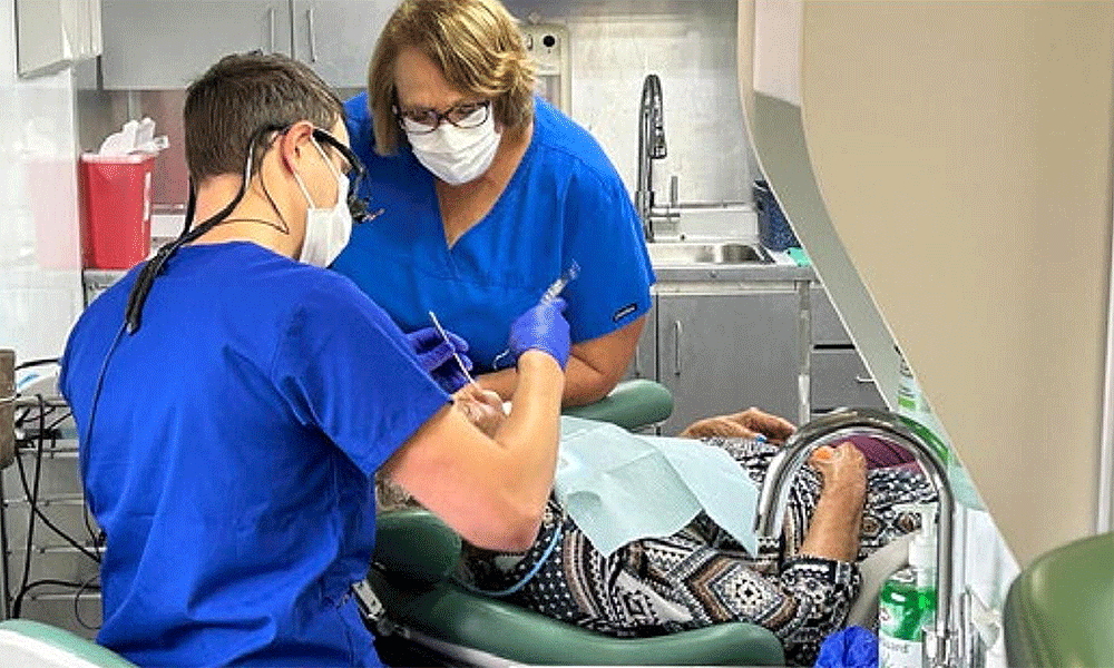 Dr. Jason Holland and dental assistant, Sarah Donaldson, work on a patient in the mobile dental clinic. Courtesy photo.