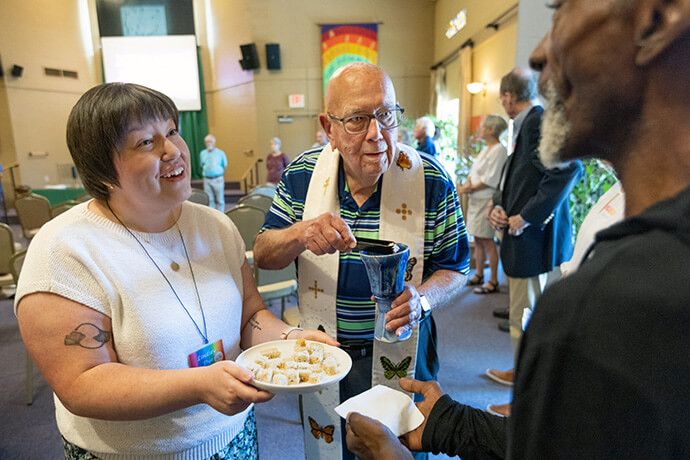 The Rev. Deen Thompson (center) assists with serving communion at Edgehill United Methodist Church, Nashville. Photo by Mike DuBose. 