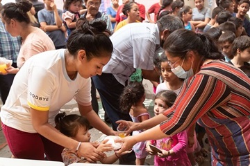 Volunteer Maria Esther Dorame Villanueva (right) helps serve lunch to families staying at the Posada del Migrante shelter in Mexicali, Mexico. Villanueva is from El Divino Redentor Methodist Church in Mexicali. Photo by Mike DuBose, UM News.