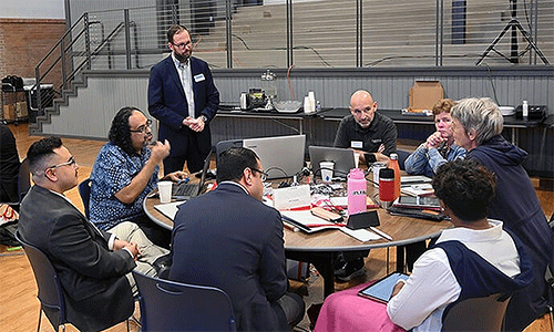 David Scott (standing), senior director of mission theology and strategic planning for the United Methodist Board of Global Ministries, listens to members of the Connectional Table discuss colonialism Oct. 24 during orientation training in Dallas. Photo by Jim Patterson, UM News.