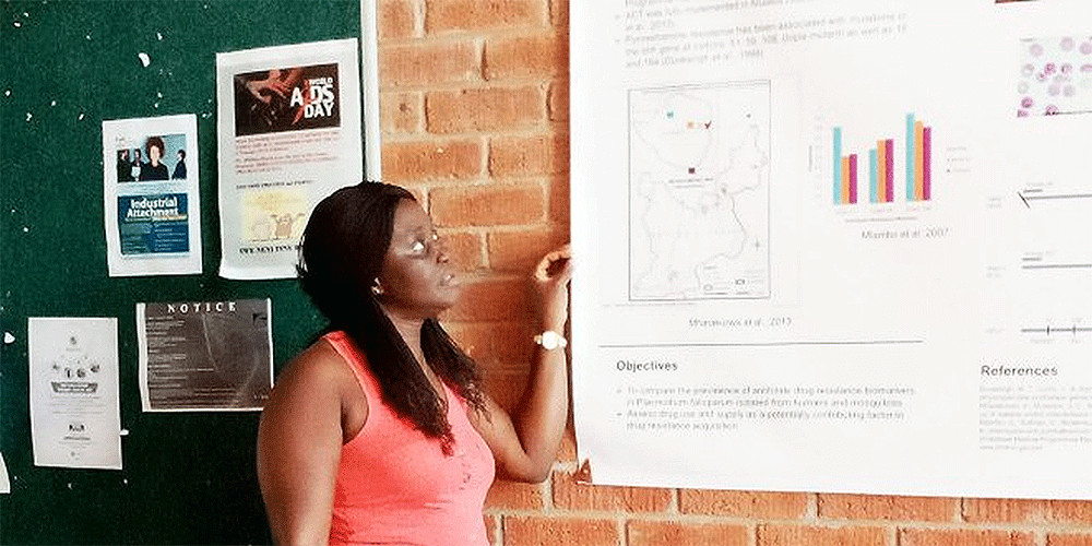 Martha Fatoma, from Sierra Leone, reads the College of Health, Agriculture and Natural Science (CHANS) billboard at Africa University in Zimbabwe. Fatoma is a World Communion Scholar who studied at Africa University for a Bachelor of Science in Nursing. Photo: Courtesy of Martha Fatoma