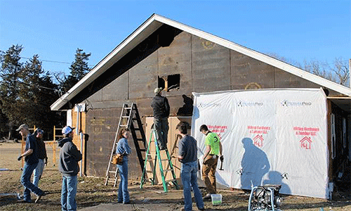  “Yep – there be birds in there.” Kansas State University students get to work on the siding project for Kulli Tuklo UMC in Idabel, Oklahoma. Photo: Courtesy of Oklahoma Indian Missionary Conference
