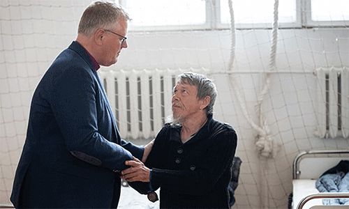 During a 2022 visit to Ukraine, United Methodist Bishop Christian Alsted visits with Alexandre, who is living in the gymnasium at the Onokivtsi Secondary School near Uzhhorod. Being present reassures victims of the war that the church has not forgotten them, Alsted said. File photo by Mike DuBose, UM News.