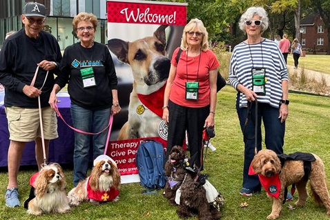A group of therapy dogs trained by the Pinnacle View United Methodist Church Pet Ministry visits students on a college campus during exam week. Photo courtesy of Gayle Fiser.