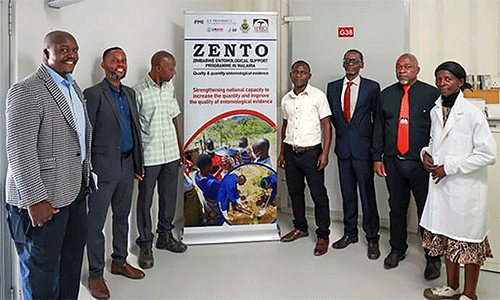 Staff with the Zimbabwe Entomological Support Program in Malaria stand inside the insectary at Africa University in Mutare, Zimbabwe, during a rededication of its research lab on Aug. 27. The program was shut down earlier this year after funding from USAID was suspended. From left are Sungano Mharakurwa, Vuyisile Mthokozisi Mathe, Joseph Makanda, Fanuel Toto, Hieronymo Masendu, Petros Kawadza and Violla Chimwayi. Photo by Ben Smith, UM News