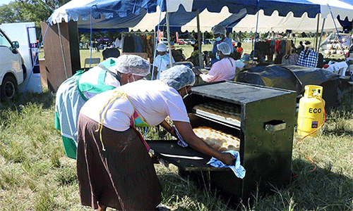 Members of Divine Grace Bakery remove buns from a gas oven at a Chitungwiza Marondera District business expo as they showcase their newly acquired baking skills. Funded by a United Women in Faith grant, Divine Grace Bakery is designed to financially empower women through baking. Photo by Eveline Chikwanah, UM News. 