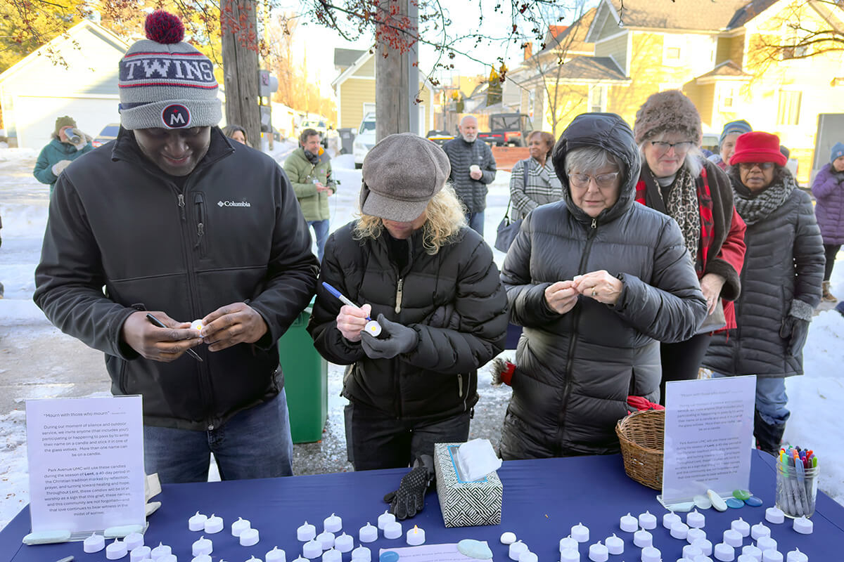 Des personnes prennent des bougies votives à piles et écrivent leurs prières lors d'une veillée de prière organisée le 9 janvier par l'Eglise Méthodiste Unie Park Avenue de Minneapolis. L'Eglise se trouve à seulement deux pâtés de maisons de l'endroit où un agent fédéral de l'Immigration and Customs Enforcement a mortellement blessé Renee Good, 37 ans. Lors des offices dominicaux, les fidèles de Park Avenue et d'autres congrégations méthodistes unies ont rendu hommage à Renee Good, ont pleuré les violences commises cette semaine par des agents fédéraux et ont trouvé du réconfort dans la présence de Dieu. Photo gracieusement fournie par l'église méthodiste unie Park Avenue.