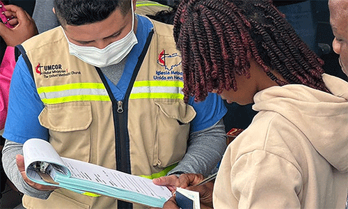 Yilmer Duarte (left), with the United Methodist clinic, helps a migrant seeking health services at the Irregular Migrant Assistance Center in Danlí, Honduras. Photo by the Rev. Gustavo Vásquez, UM News.