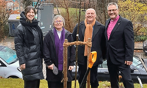 (From left) Pastor Rebekka Tibbe of the Evangelical Lutheran Church of St. Jürgen, the Rev. Gillian Horton-Krüger of Flensburg United Methodist Church and her husband, Peter Krüger, and United Methodist Bishop Werner Philipp pose for a photo after planting an apple tree at the St. Jürgen church, where the Flensburg congregation meets. Photo by Isabel Philipp.