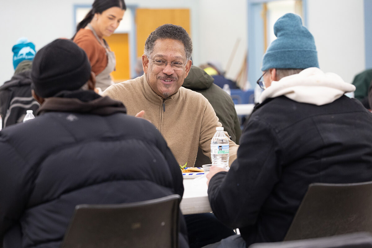 Le révérend Stephen Handy (au centre) est assis avec Tommas Bolton (à gauche) et Kevin Haas lors d'un repas communautaire à l'Église Méthodiste Unie McKendree à Nashville, dans le Tennessee. « Nous nous asseyons avec eux », a déclaré Handy. « Nous voulons connaître leurs noms, nous voulons entendre leurs histoires. » Handy est pasteur à McKendree depuis 2009 et supervise également une vingtaine d'églises urbaines entre Nashville et Memphis, qu'il encourage à sortir dans leurs quartiers. Photo de Mike DuBose, UM News. 
