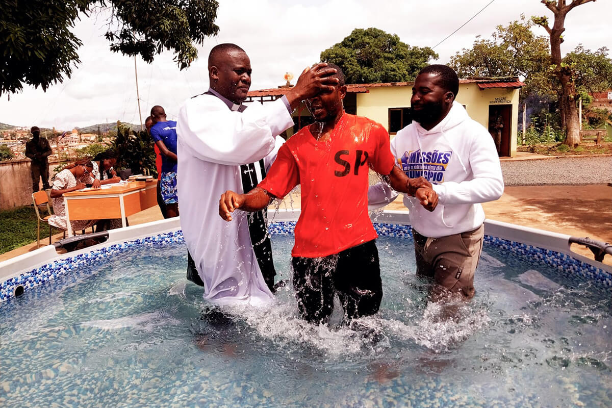 Rev. Valdo Manuel baptizado um dos 38 reclusos com a ajuda do evangelista Yuri Bartolomeu. Foto cortesia da comissão de comunicação da Igreja Central de Ndalatando, Notícias MU.