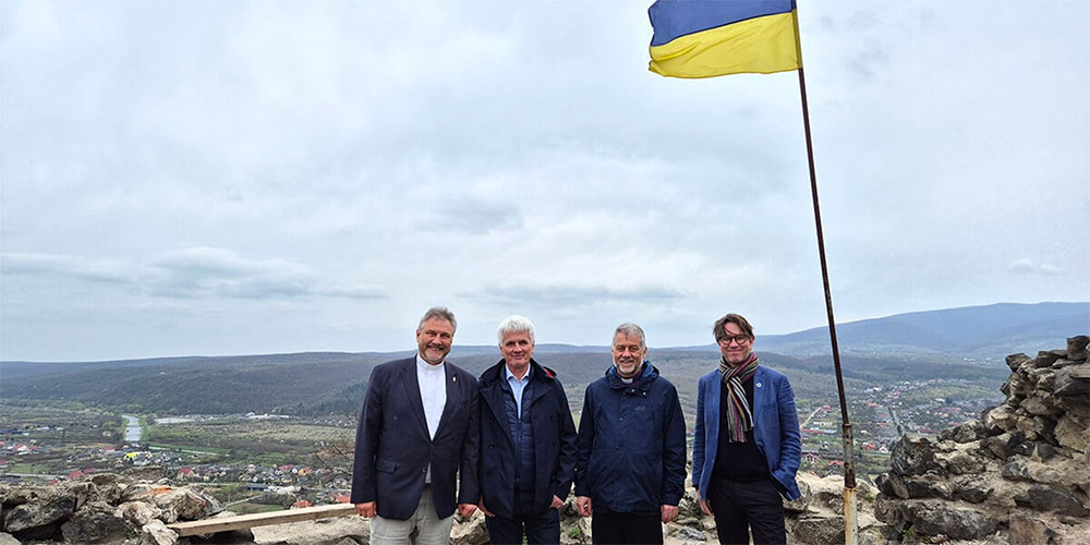  (From left) Bishop Werner Philipp, local preacher István Pásztor from Hungary, Bishop Stefan Zürcher and Bishop Knut Refsdal stand under a Ukrainian flag at Nevytske Castle, north of Uzhhorod, during their visit to Ukraine on March 26-30. The bishops’ trip was intended as a sign of solidarity and a reminder to people in Ukraine that they have not been forgotten. Photo courtesy of EmK-Öffentlichkeitsarbeit Germany, UM News.